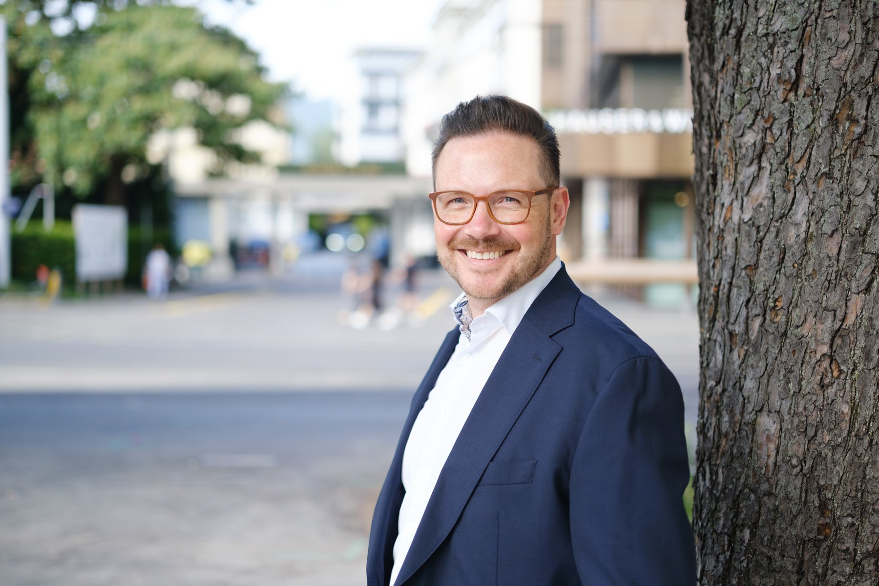 Oliver Gabor lächelnd im dunkelblauen Sakko in Zürich